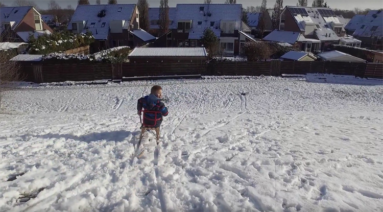 Vader en zoon spelen met drone en slee